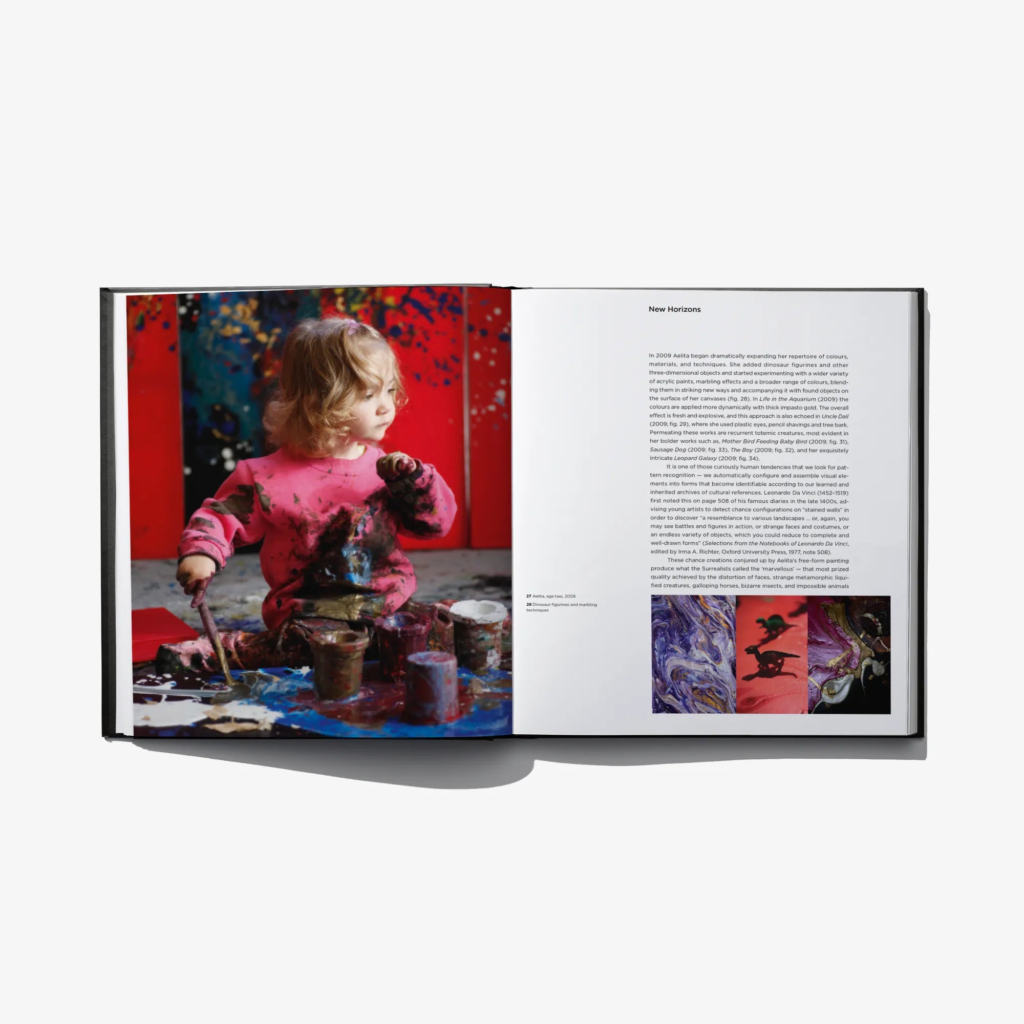 Open art book showing child painting photo on left and printed text on right