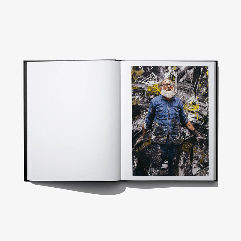 Open hardcover photo book with full-bleed color portrait of a man in a blue shirt