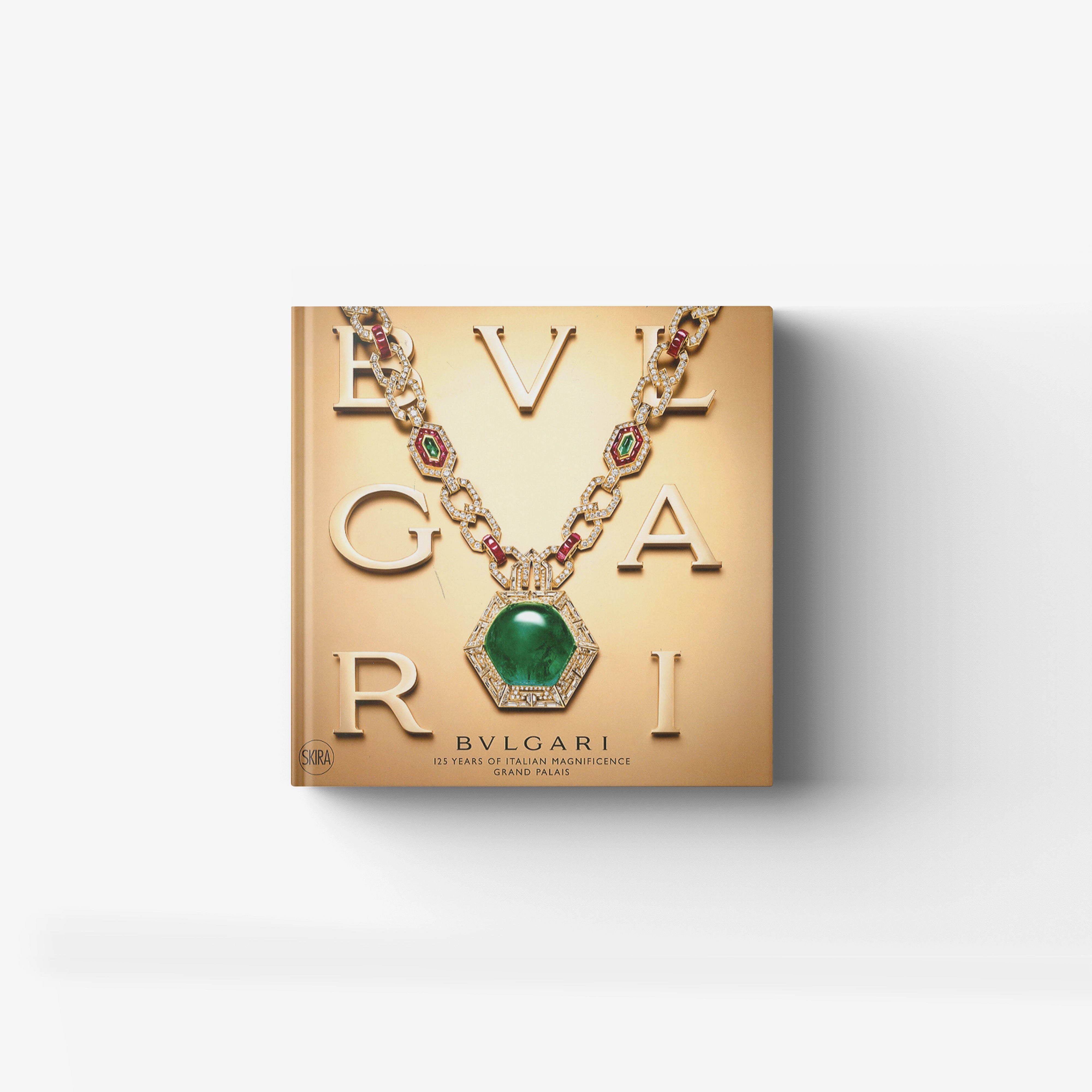 Illustrated jewelry history book in gold with Bulgari and serpent motif focus, Skira Arte, featuring a green gemstone pendant
