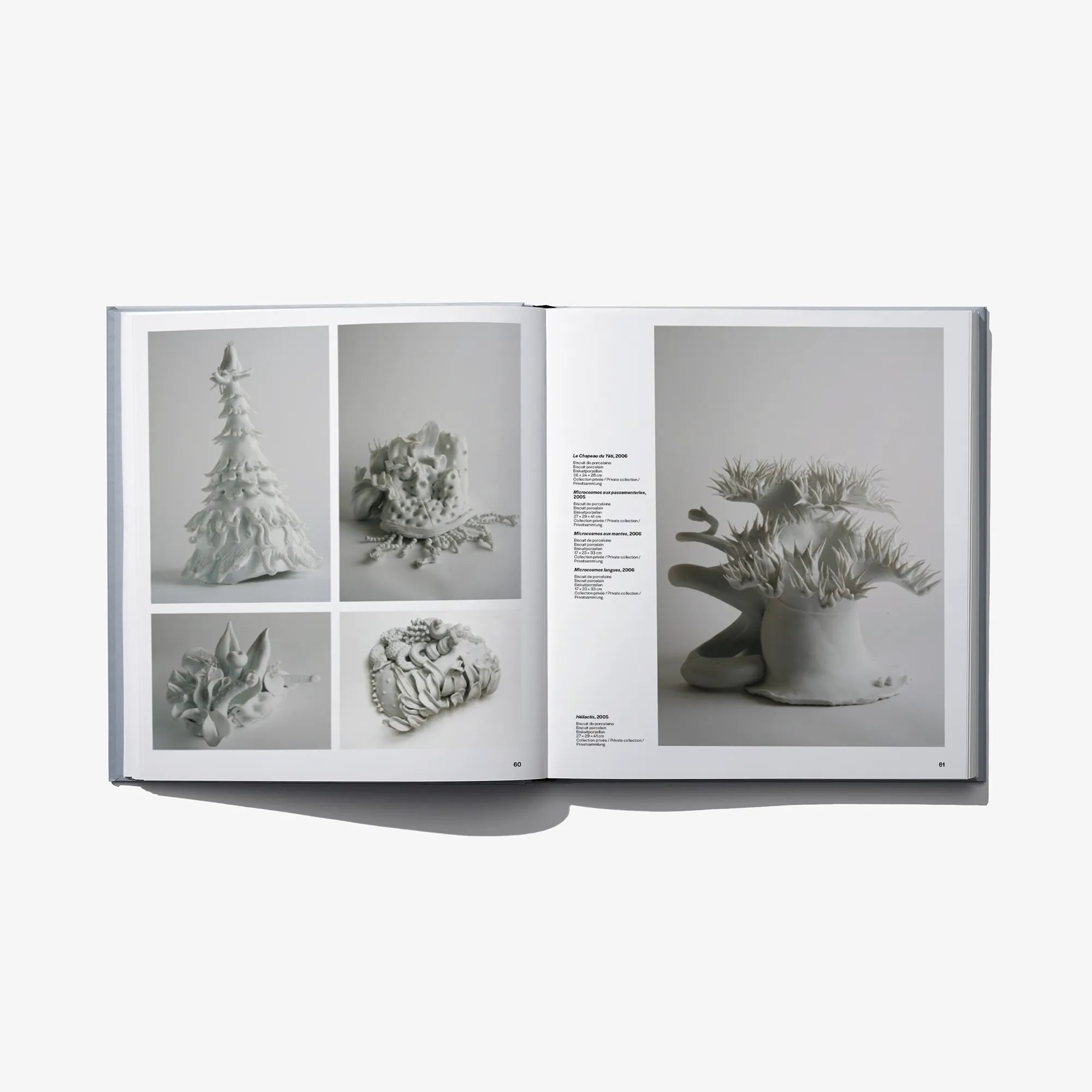 Open hardcover art book spread with framed sculpture photos on both pages