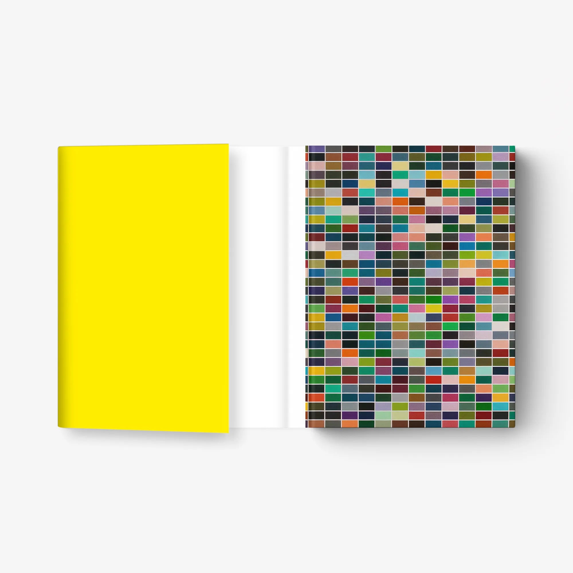 Book with bright yellow cover and open page with multicolor square mosaic print