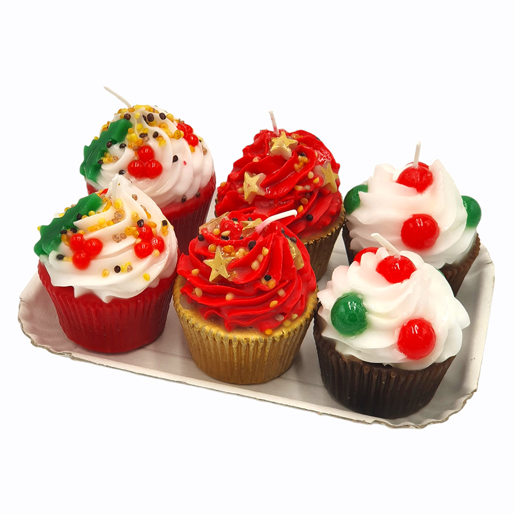 White cupcake-shaped candles on a tray, with red cherries, green accents, and sprinkles