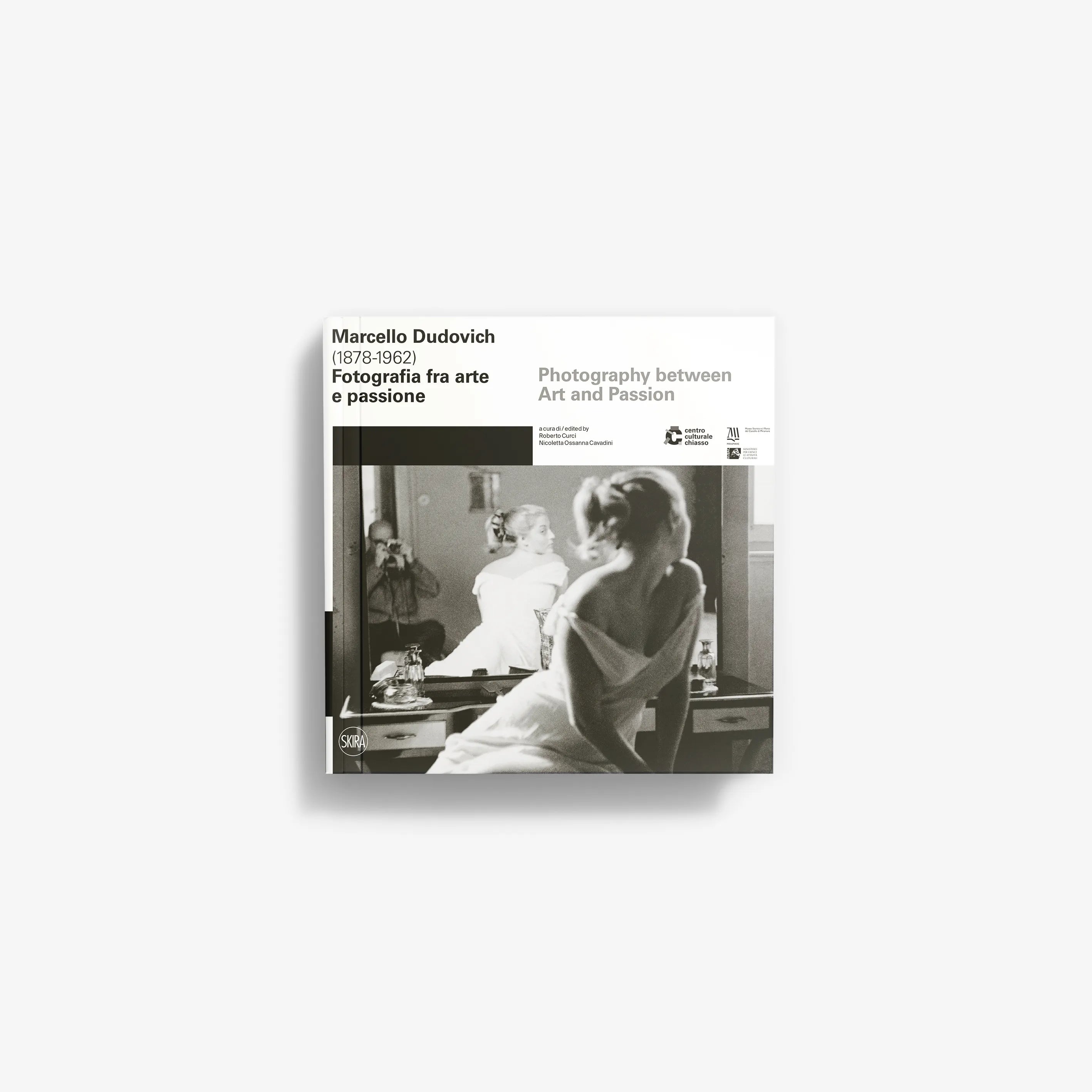 Black and white book cover featuring a vintage photograph of a woman sitting at a dressing table with a mirror and a lamp.