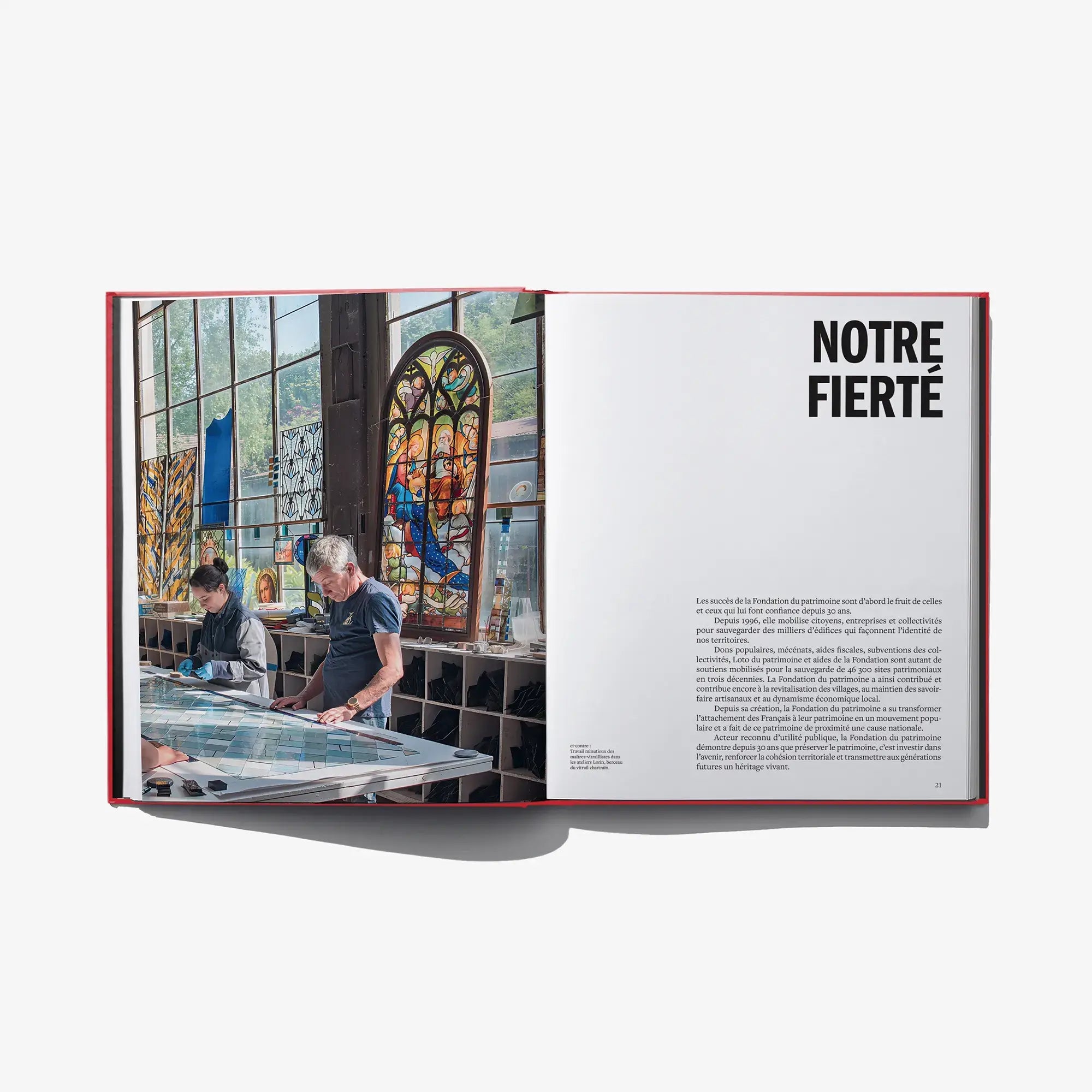 Open book spread with photo of stained-glass workshop and heading 'NOTRE FIERTE'