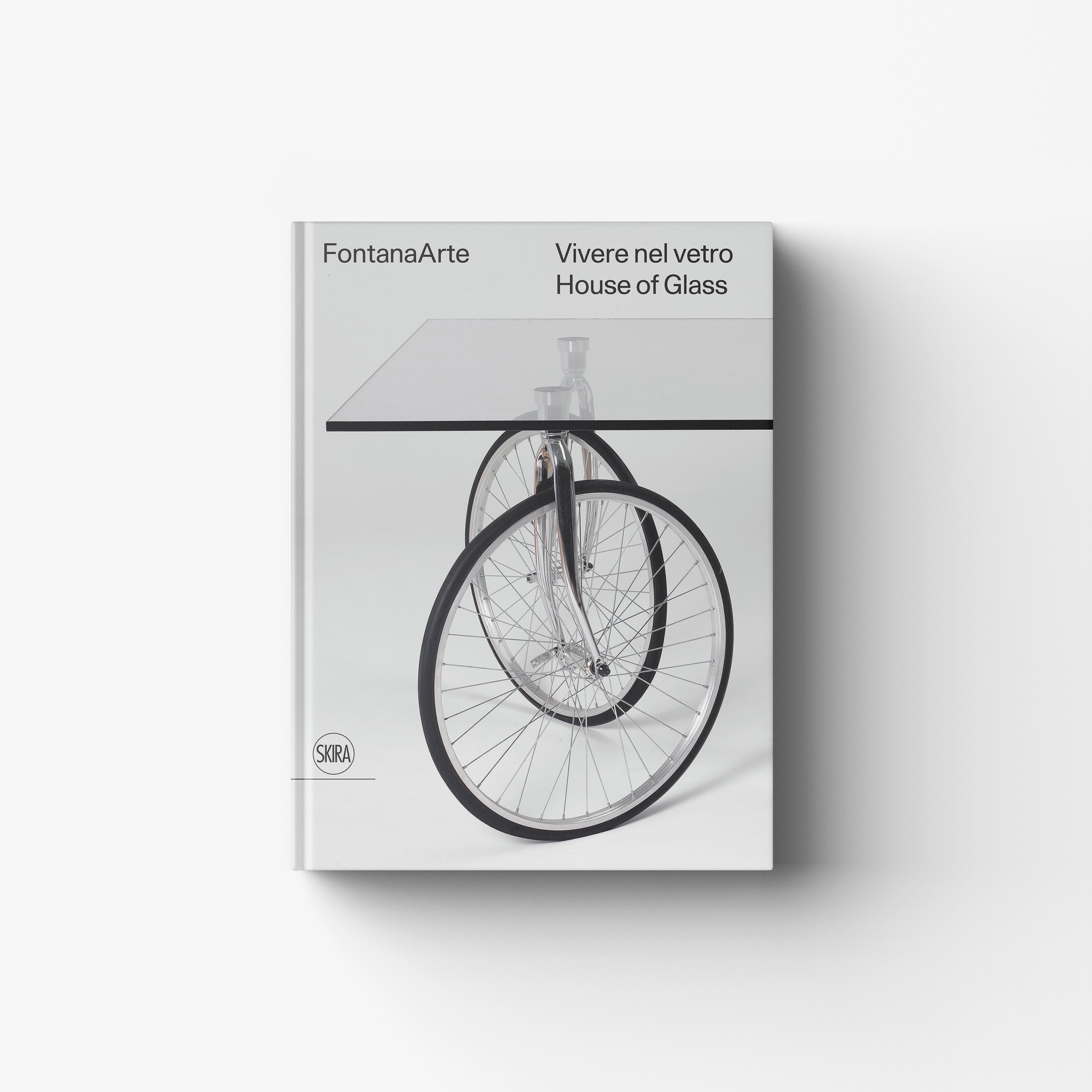 Glass book cover by Skira Arte for FontanaArte Vivere nel vetro, with bicycle wheel and House of Glass text
