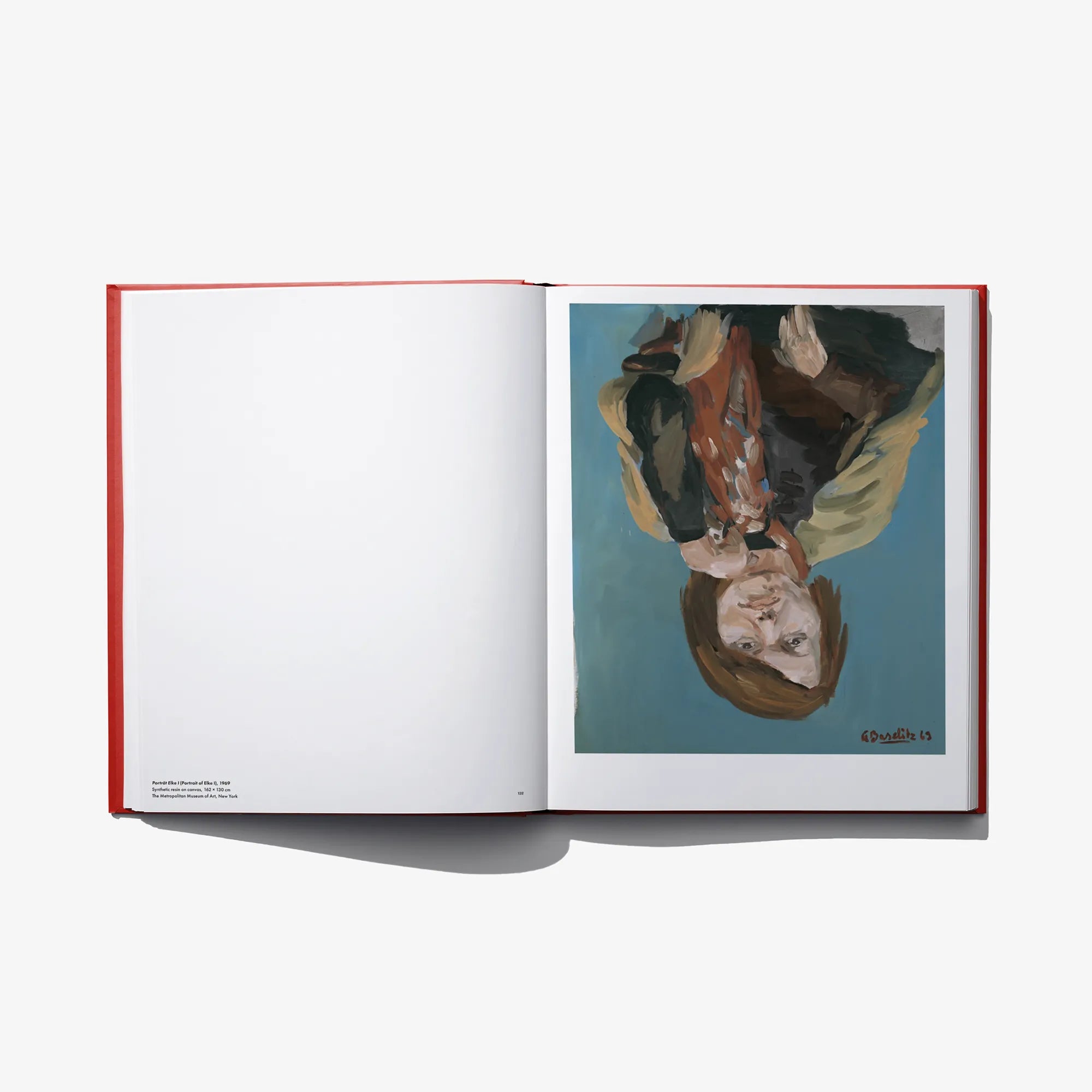 Open art book with blank left page and teal painting on right