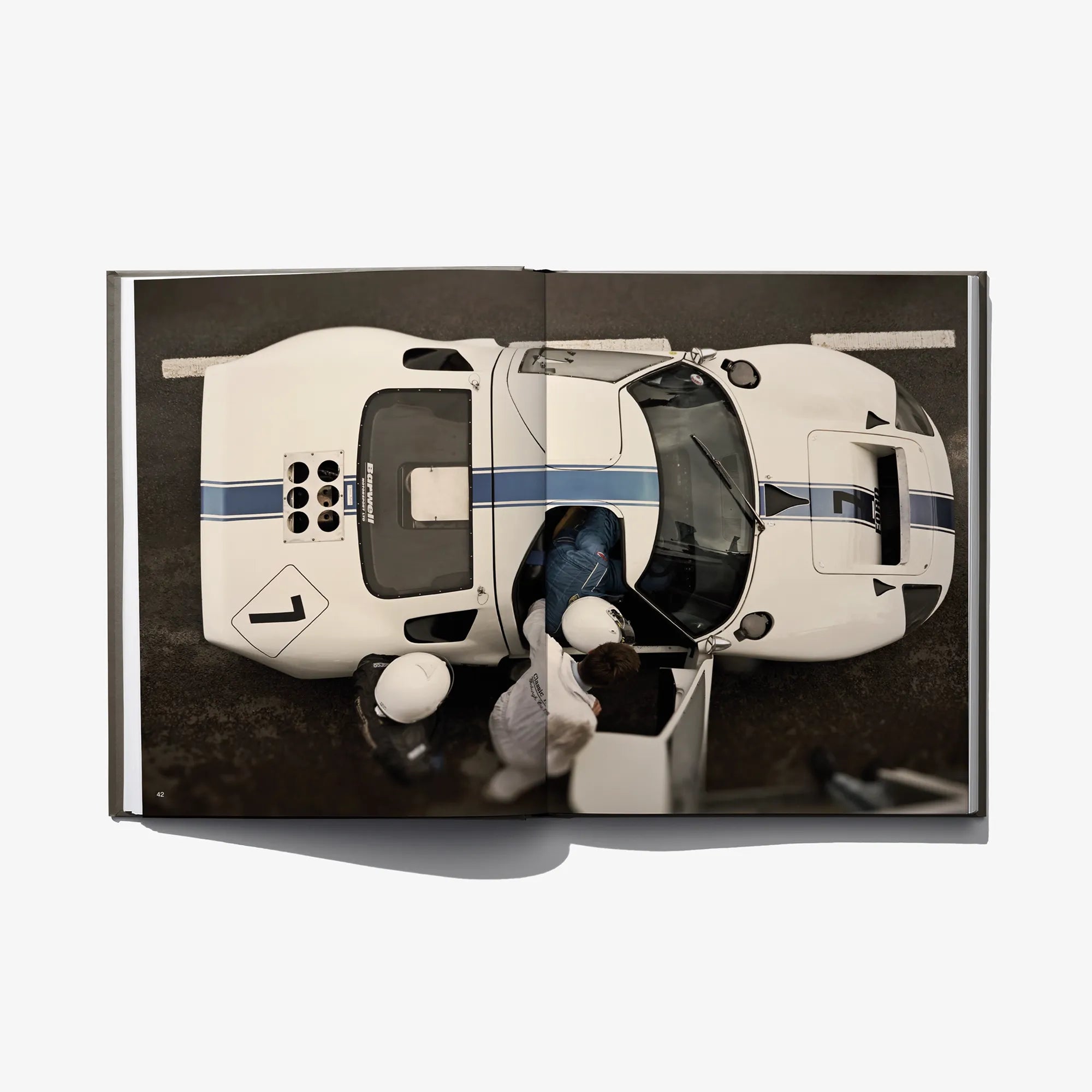 Photo book spread featuring a cream vintage racing car and cockpit detail