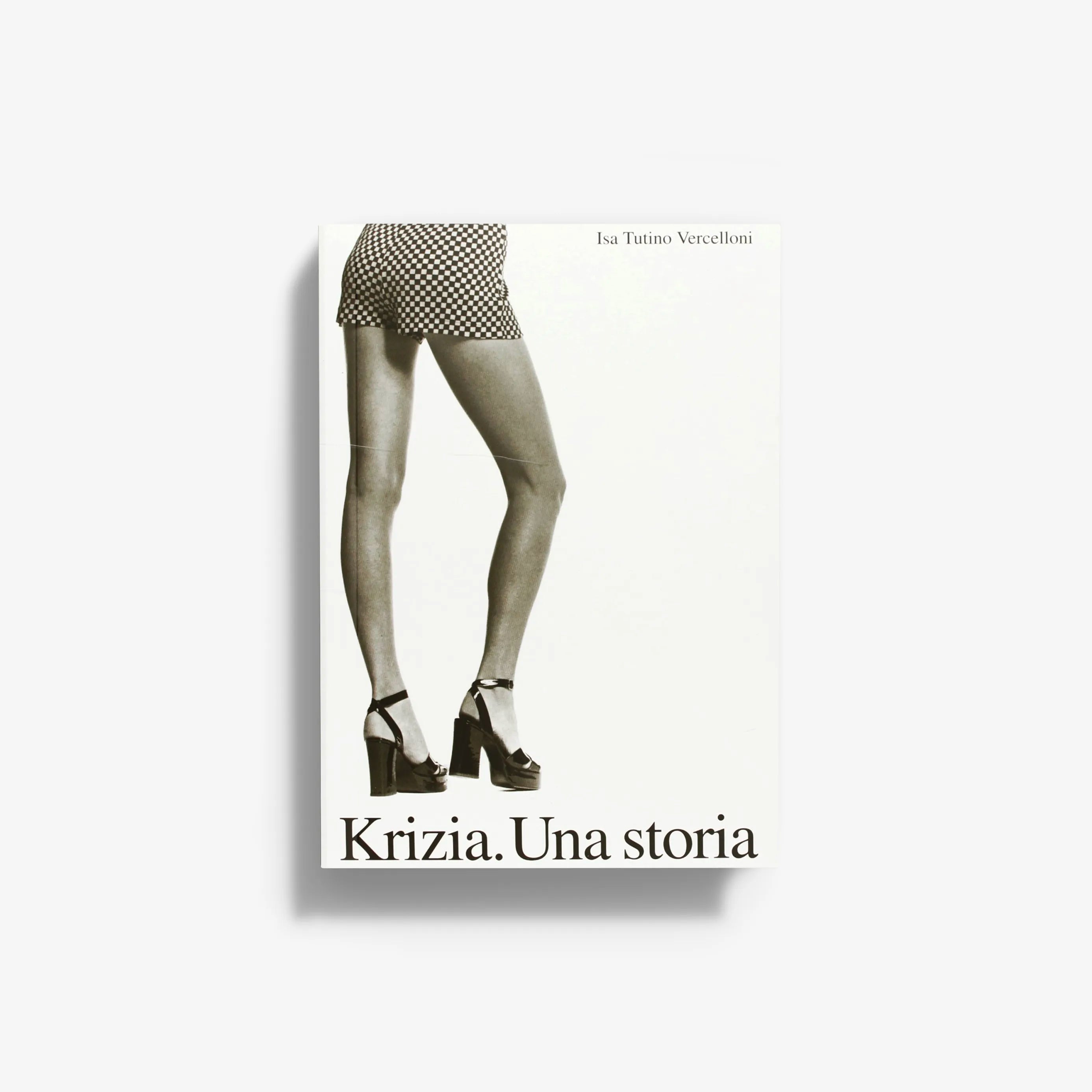Fashion history book in illustrated cover with Skira Arte branding, showing checkered shorts and bare legs