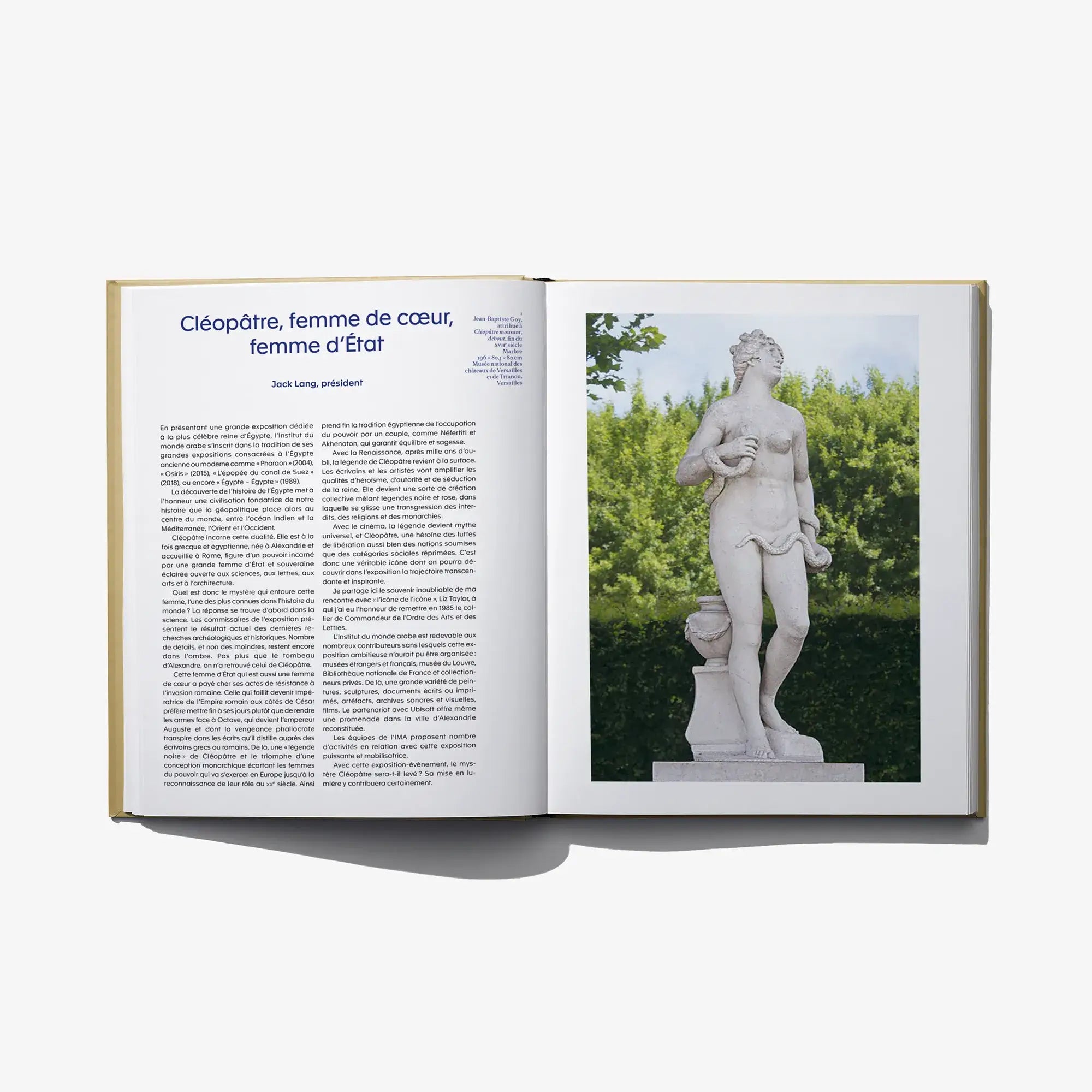 Open art book with page text and photo of a stone Cleopatra statue