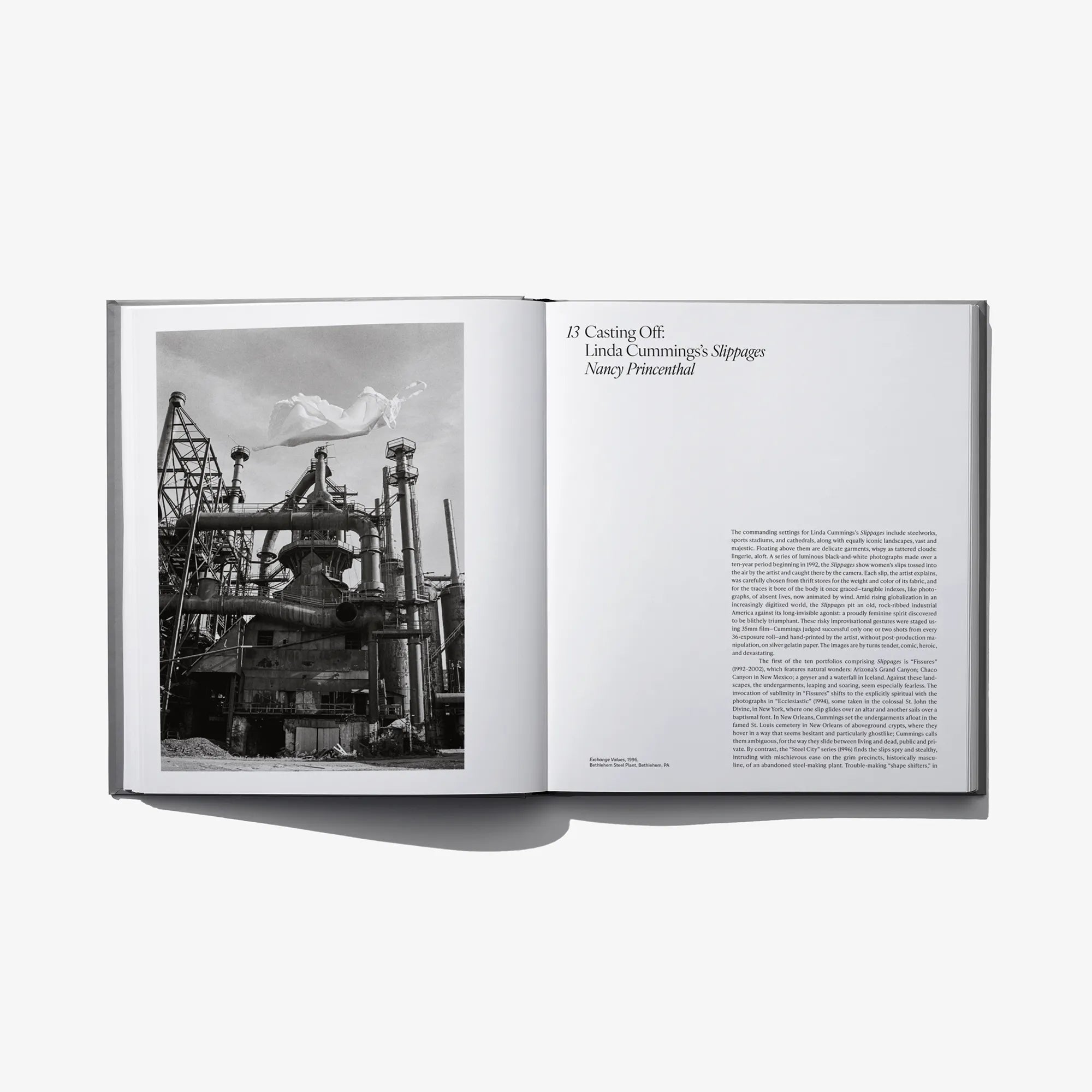 Open photo book spread with industrial grayscale photo and small text on right page