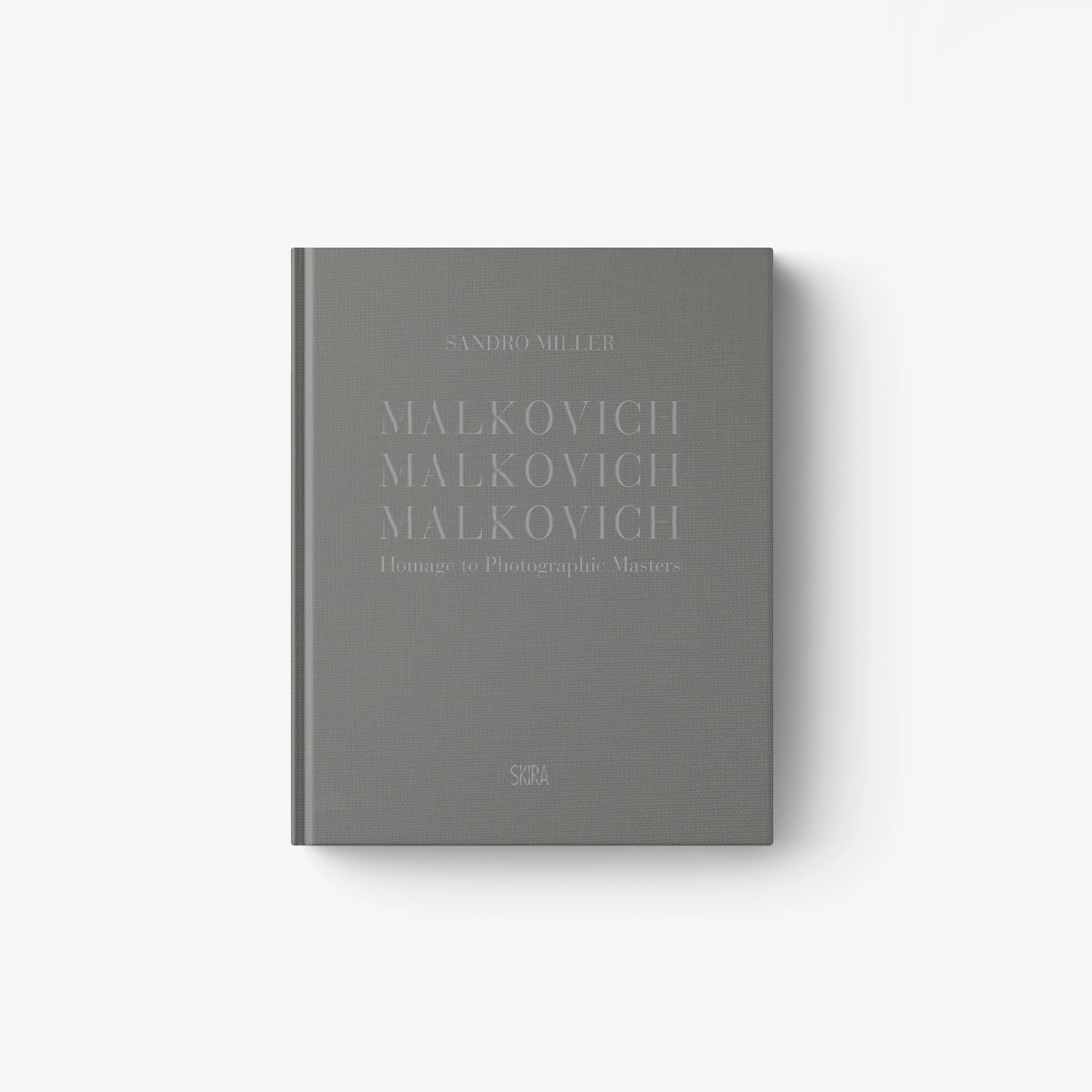 Gray hardcover book titled "Malkovich Malkovich Malkovich" with minimalist embossed text on the cover.
