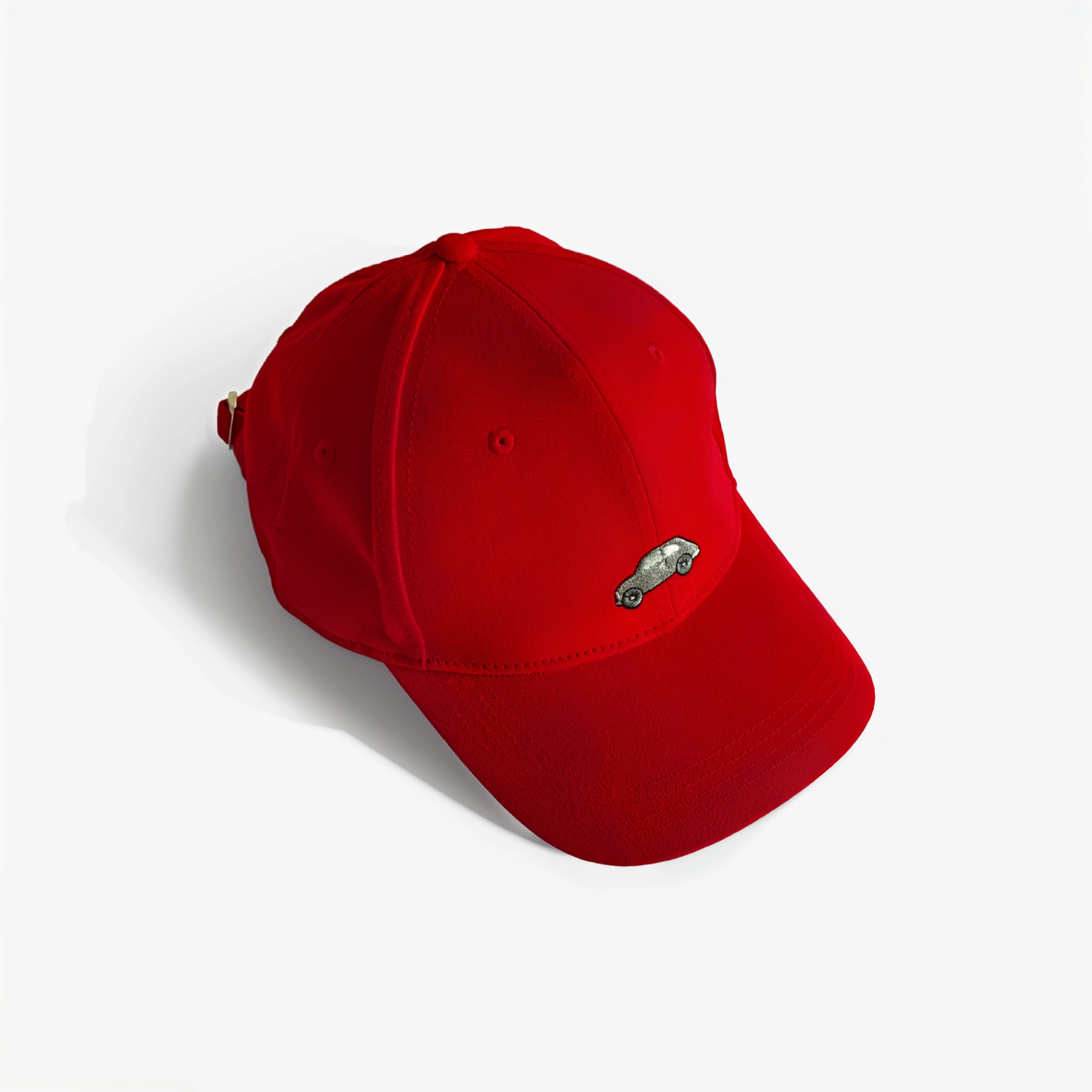 Red baseball cap with small embroidered car logo patch