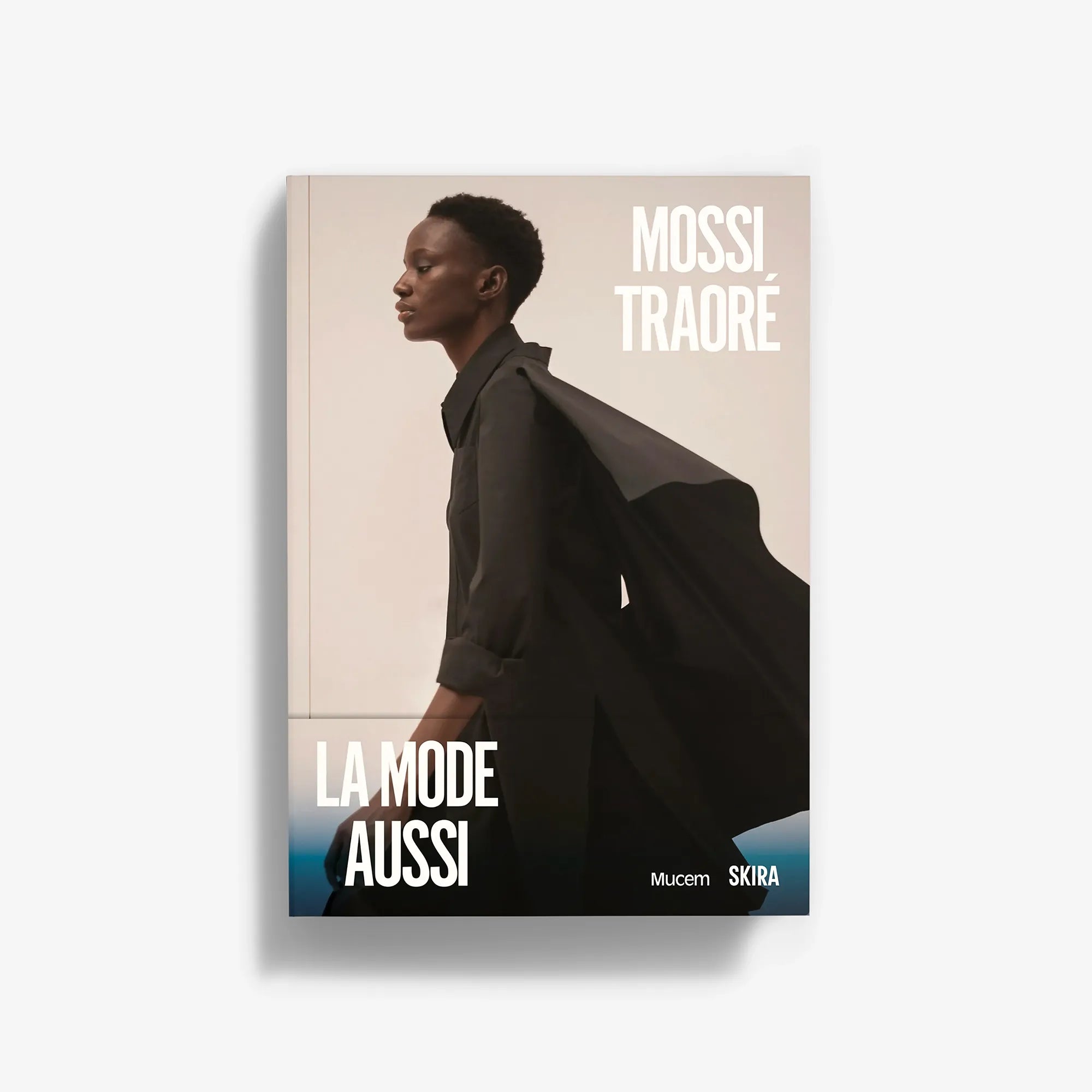 Fashion book featuring a model in a black draped coat on the cover