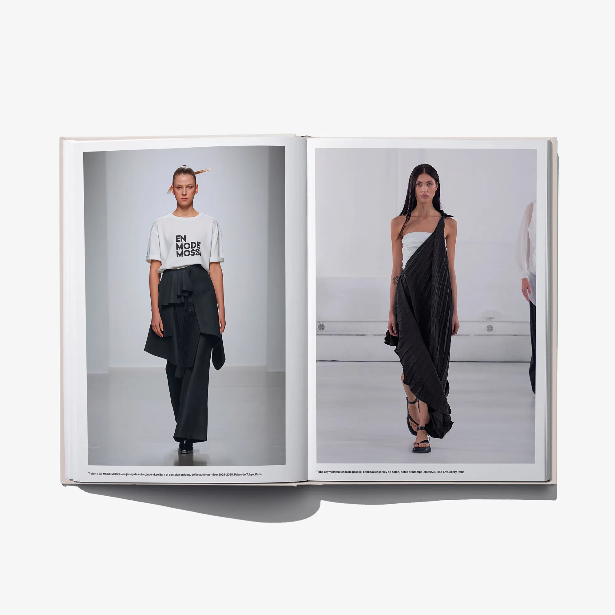 Open fashion book spread with two models in dark wrap-style outfits