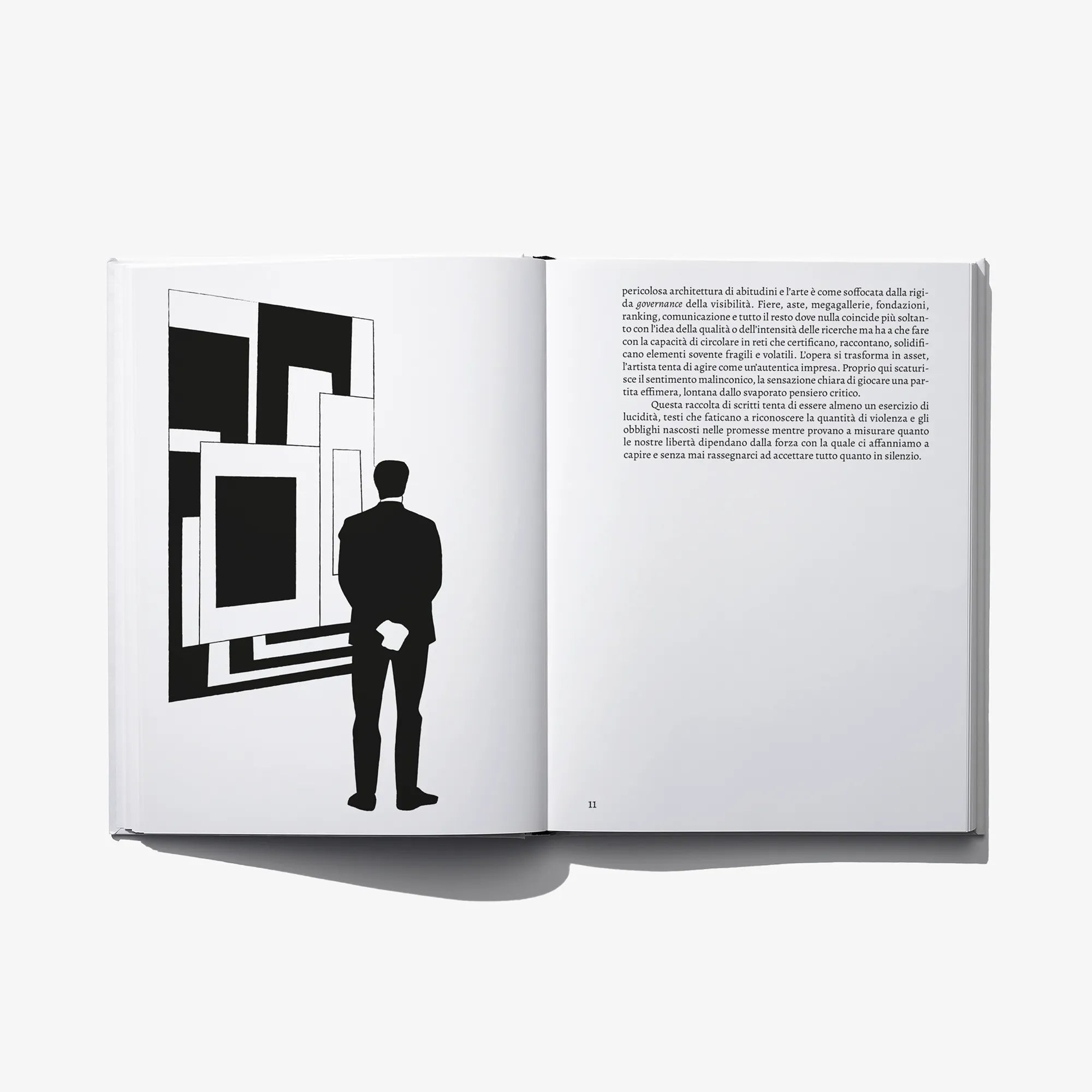 Open art book spread with black geometric illustration and full text page