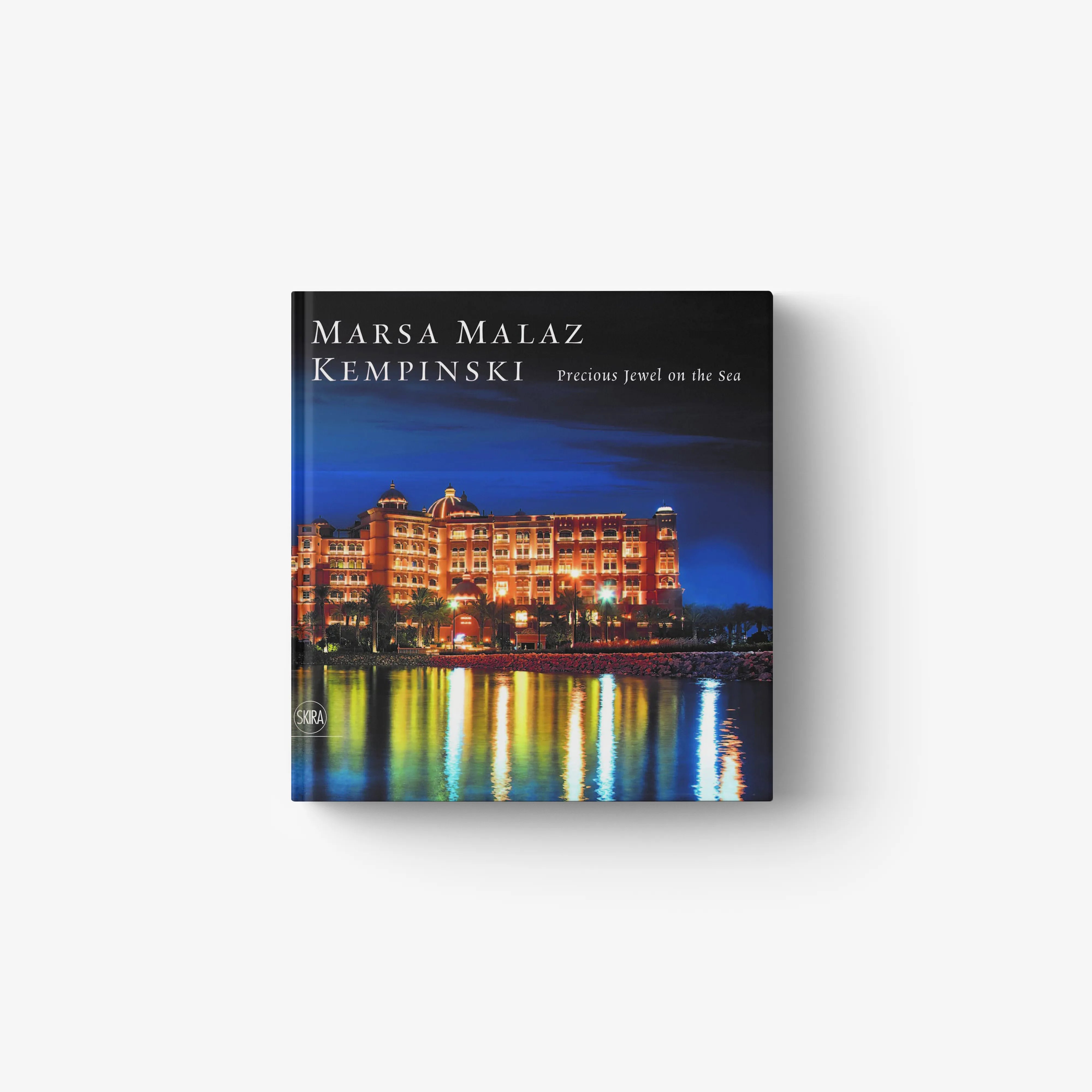 Hotel architecture book by Skira Arte with blue night sea cover and illuminated resort buildings