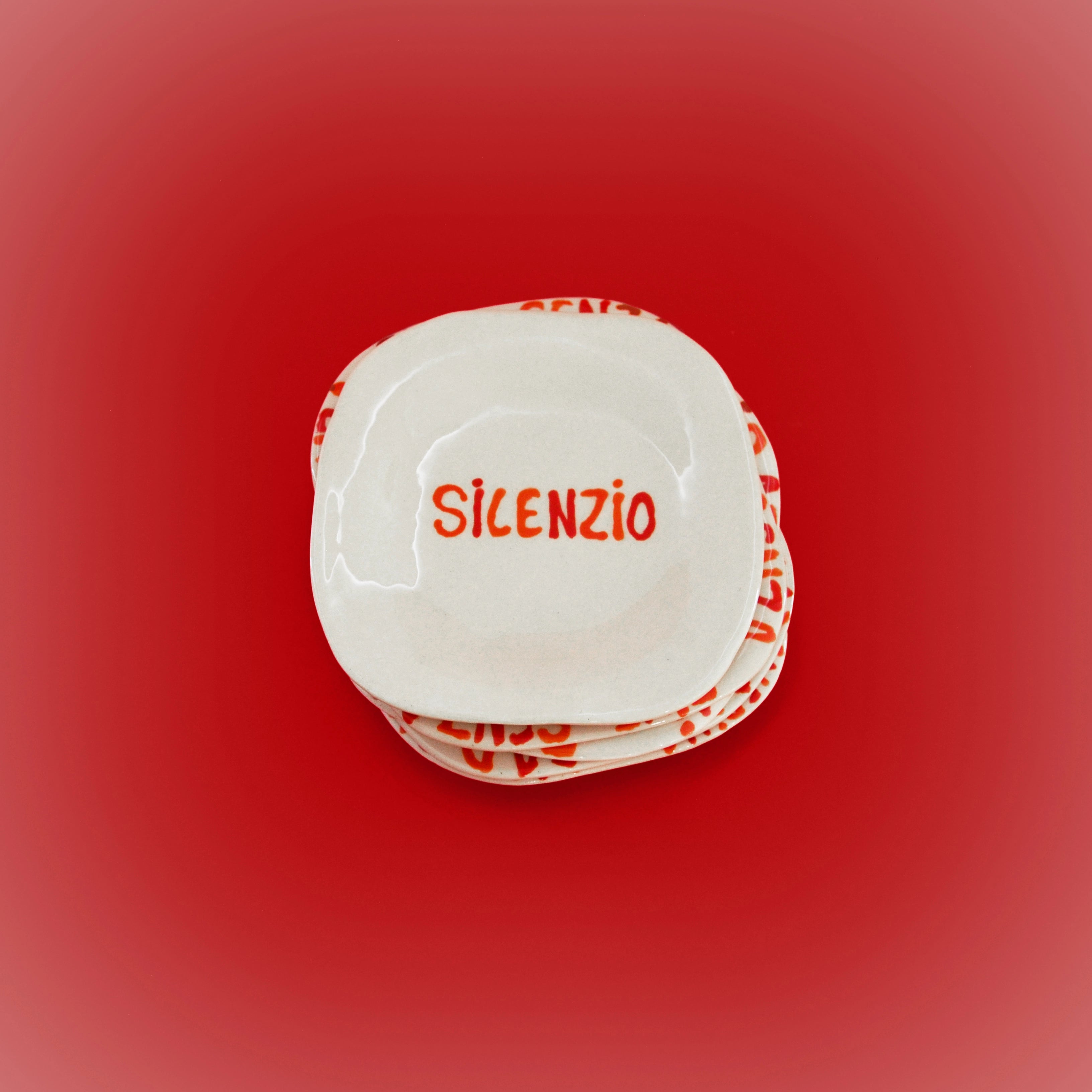 White ceramic round dish with red “SILENZIO” text