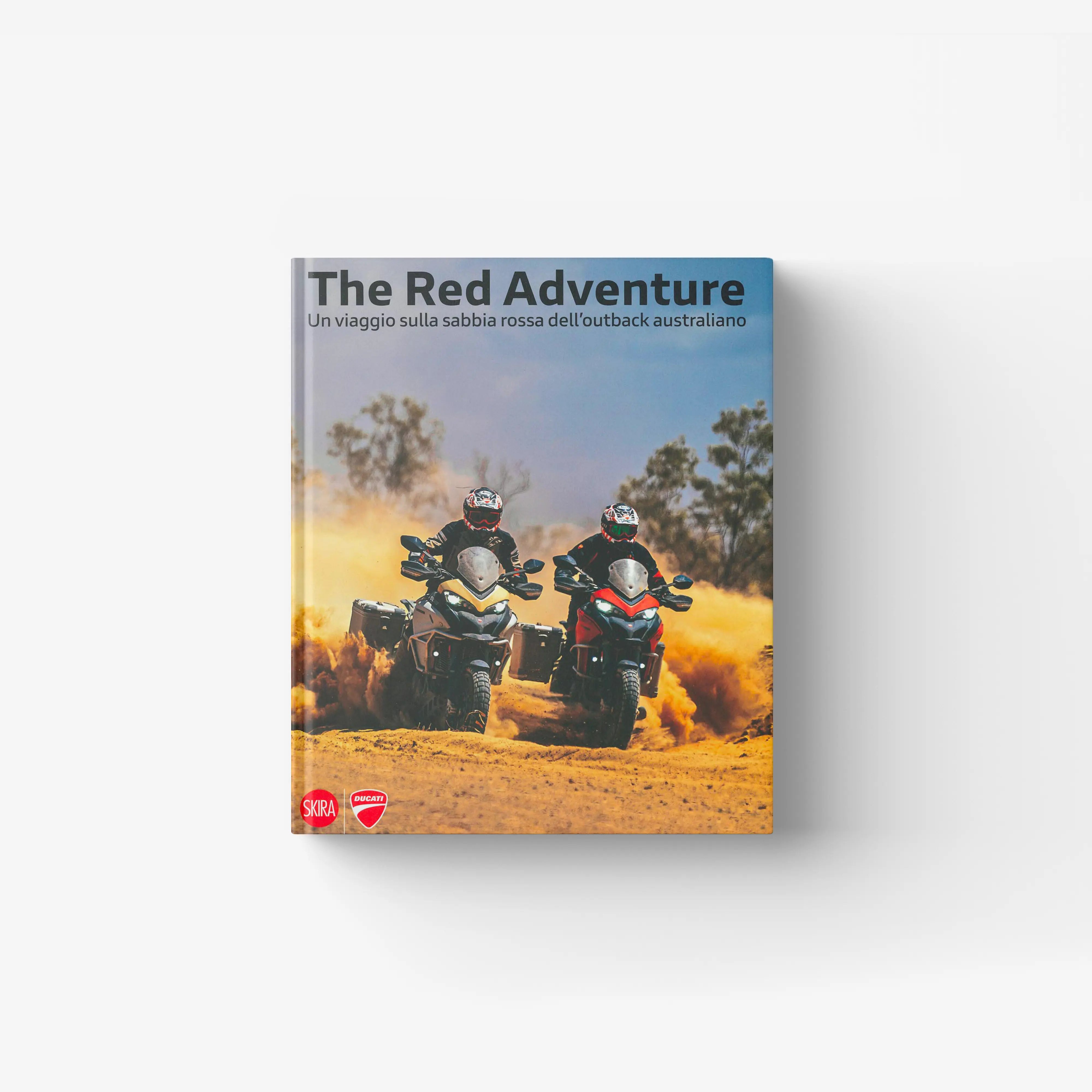 Book cover featuring two riders on motorcycles kicking up red dust in an Australian outback landscape under a clear sky.