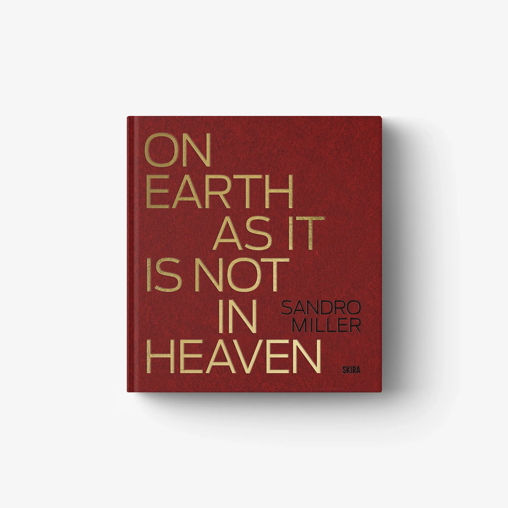 Red hardcover book with gold title text: “ON EARTH AS IT IS NOT IN HEAVEN.”