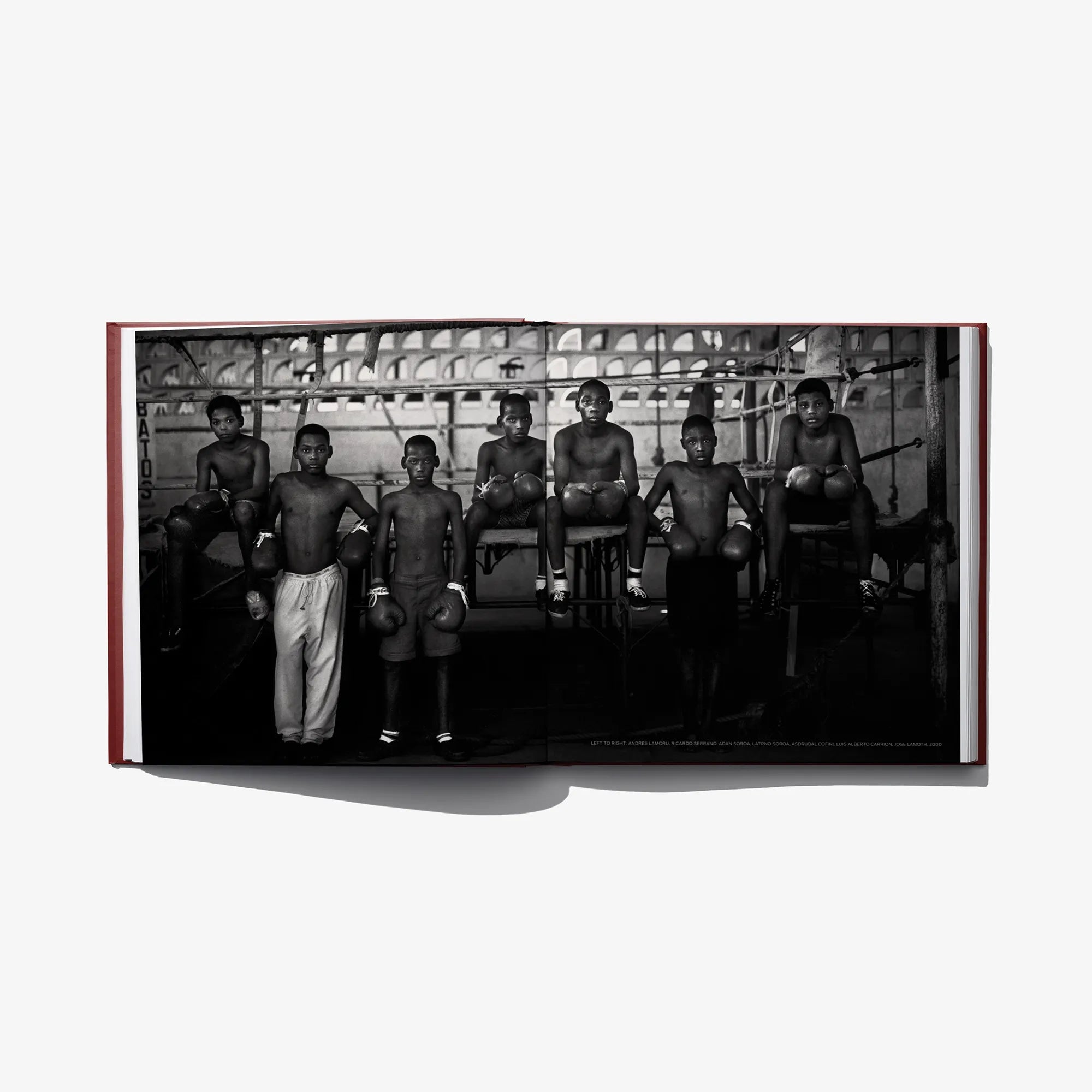 Opened hardcover book showing a black-and-white group photo of men sitting in chairs.