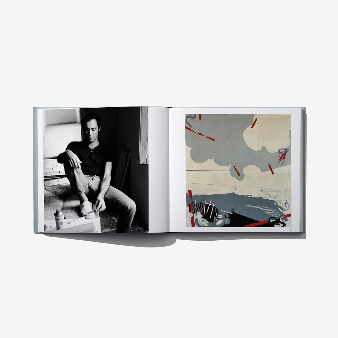 Open art catalog book with seated black-and-white portrait and colorful abstract artwork