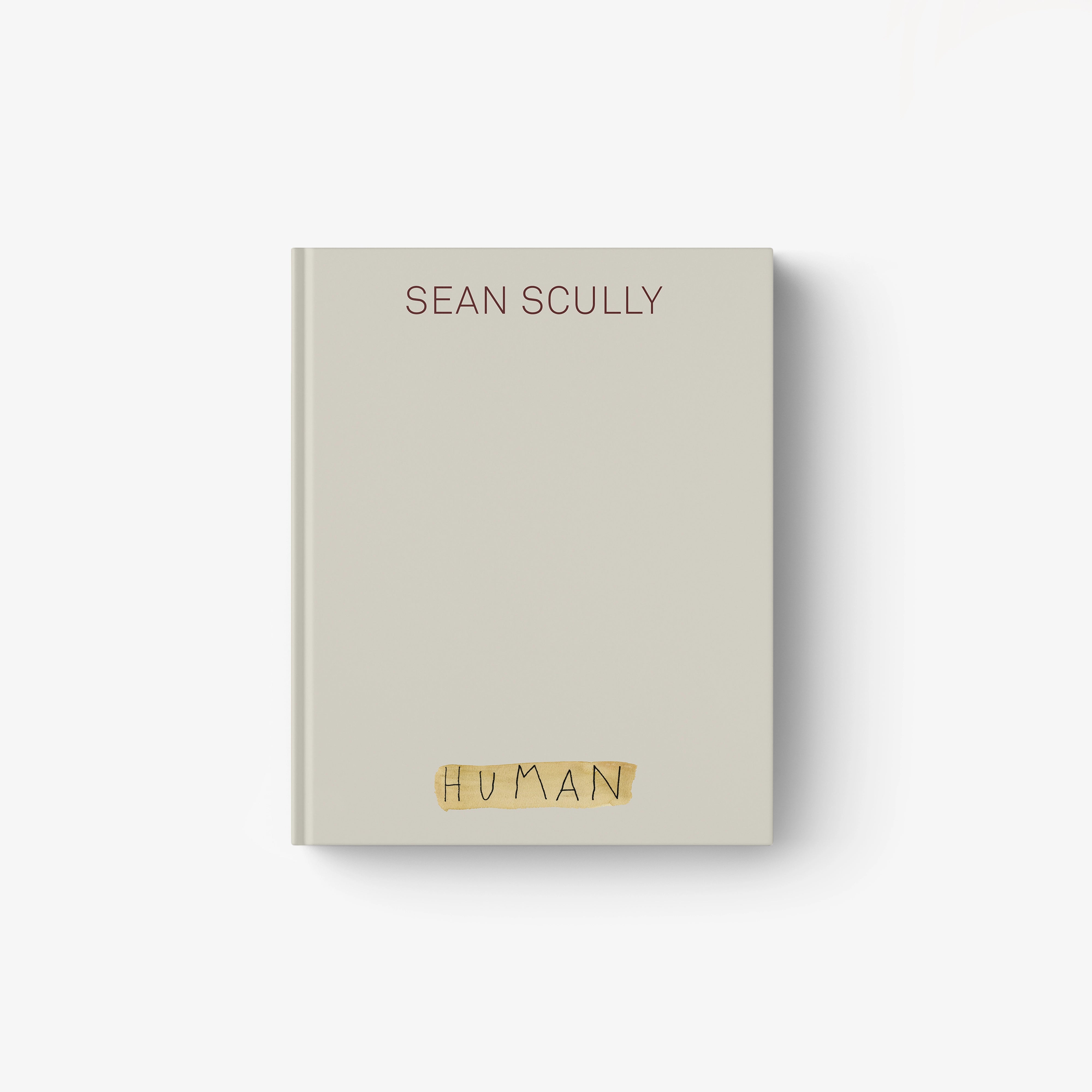 HUMAN hardcover book with beige cover and gold title lettering
