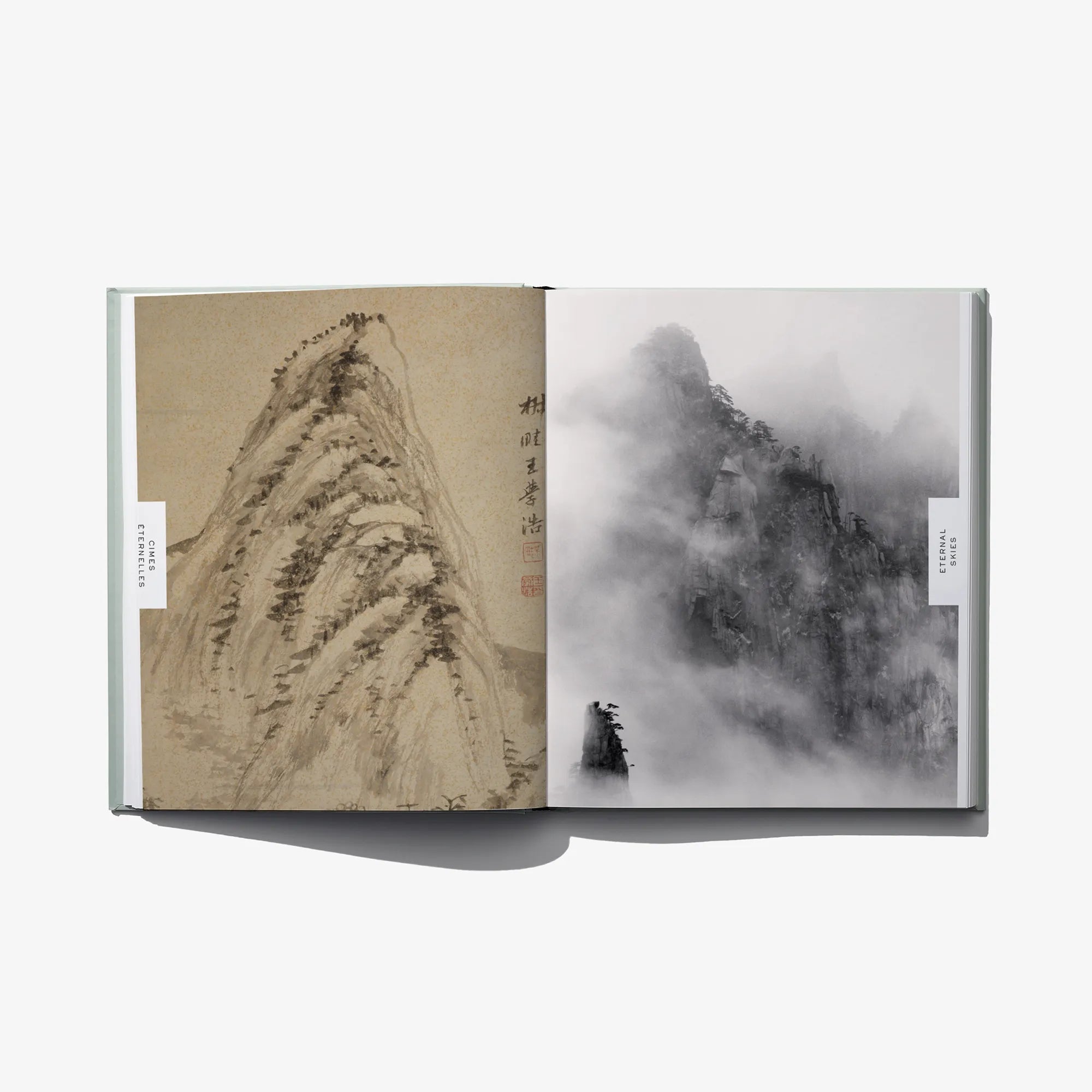 Open photo book spread: sepia mountain sketch and misty landscape scene.