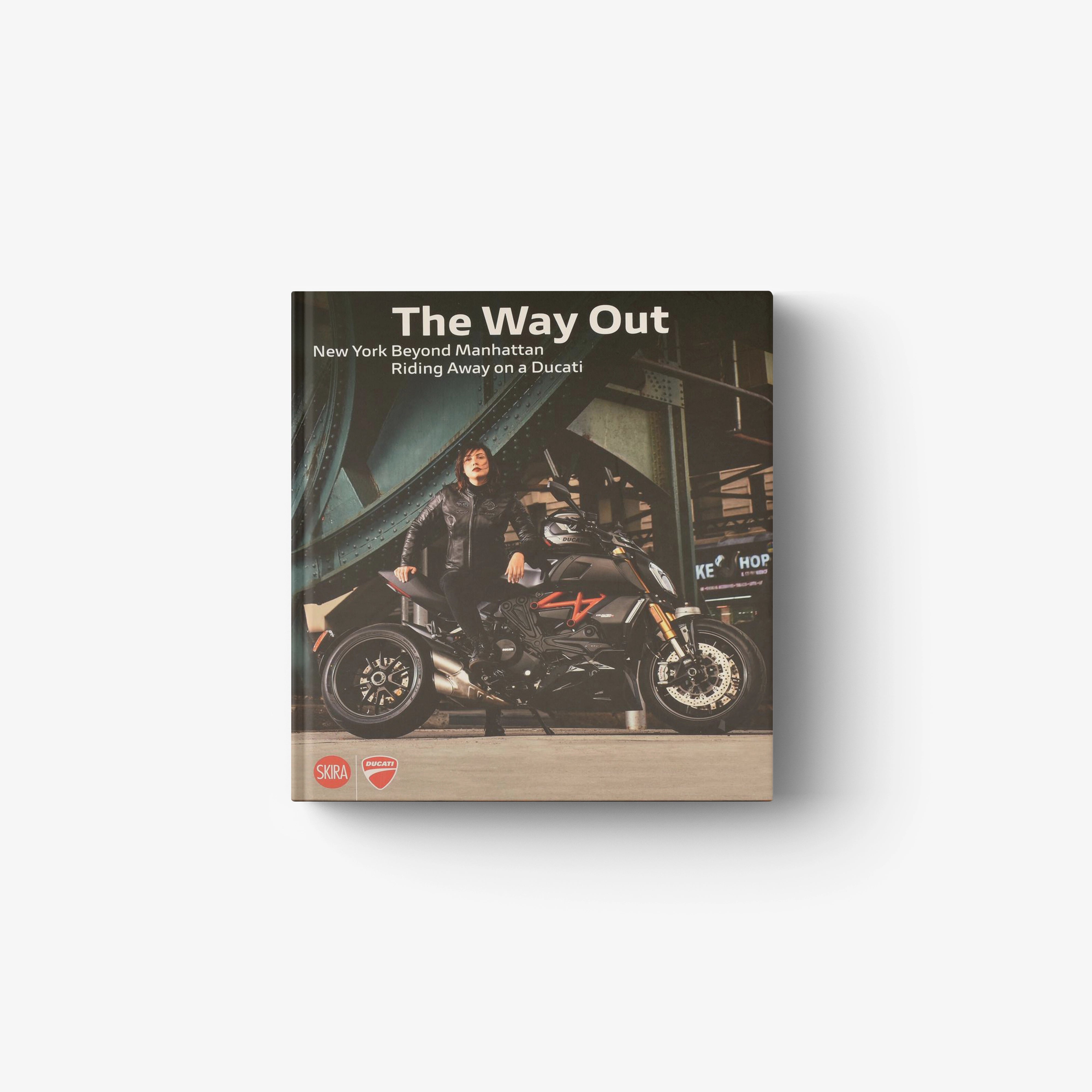 Paperback book with black cover featuring rider on a Ducati-style motorcycle