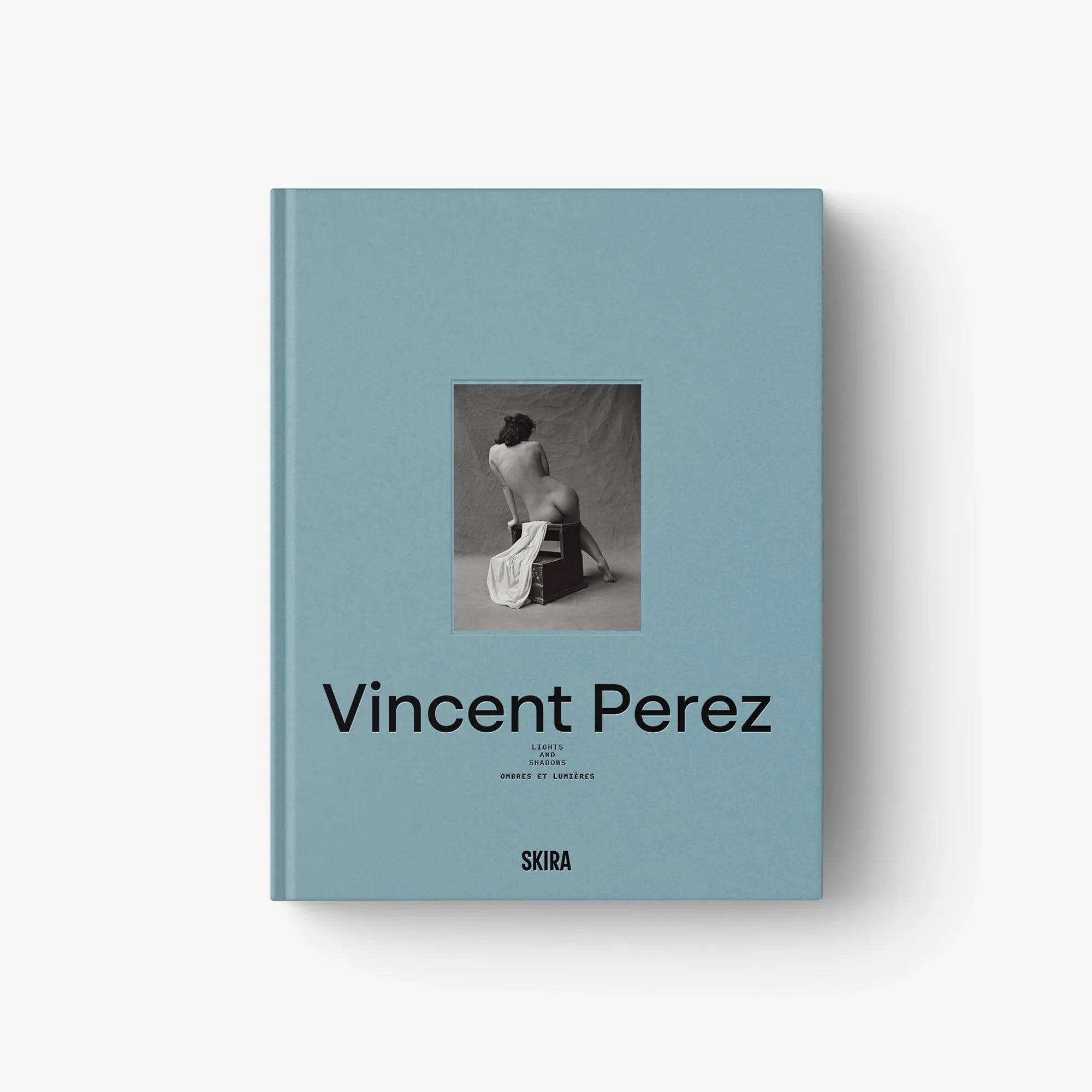 Light blue hardcover book with central photo and black title lettering