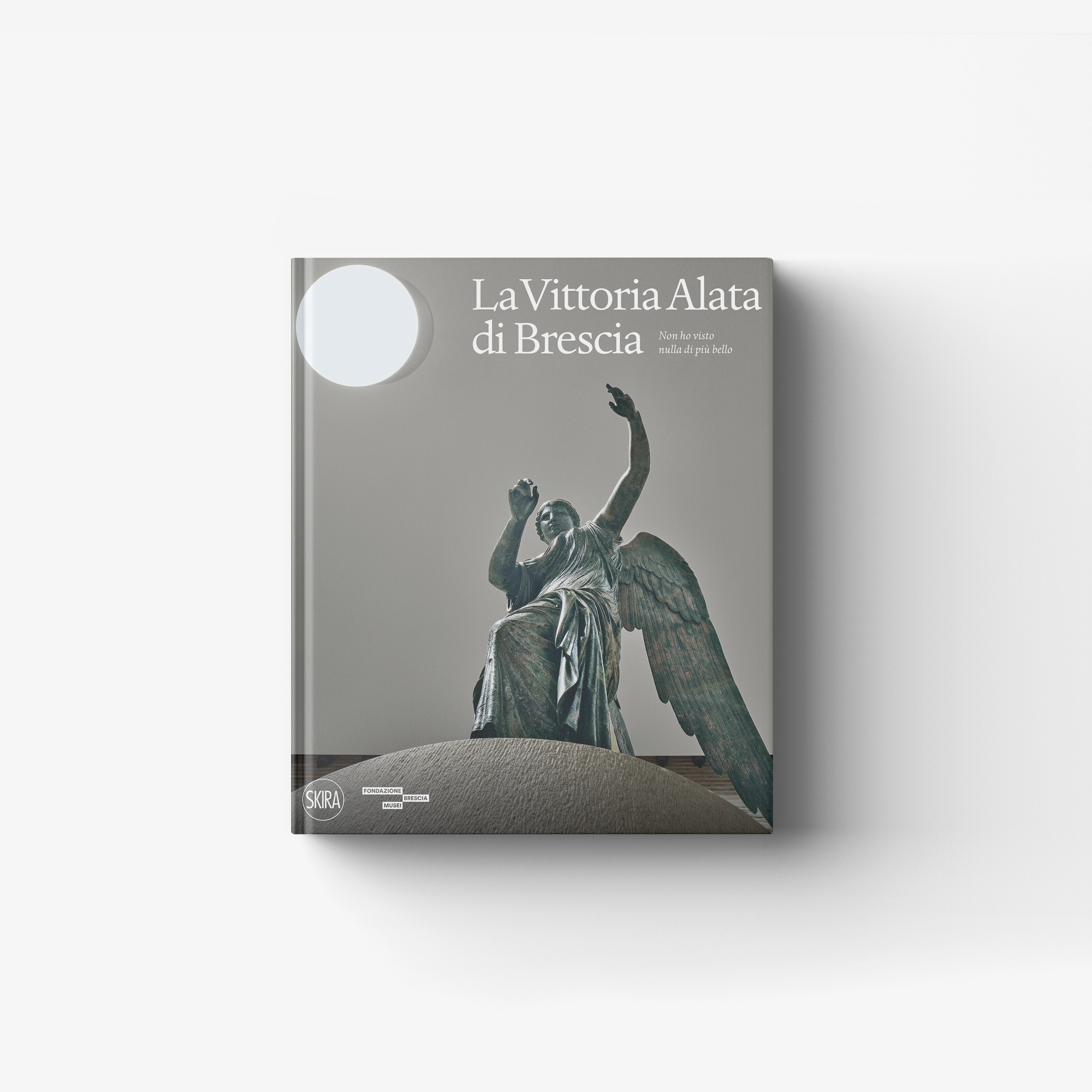 Art book La Vittoria Alata di Brescia by Skira Arte with bronze statue cover illustration and museum style setting