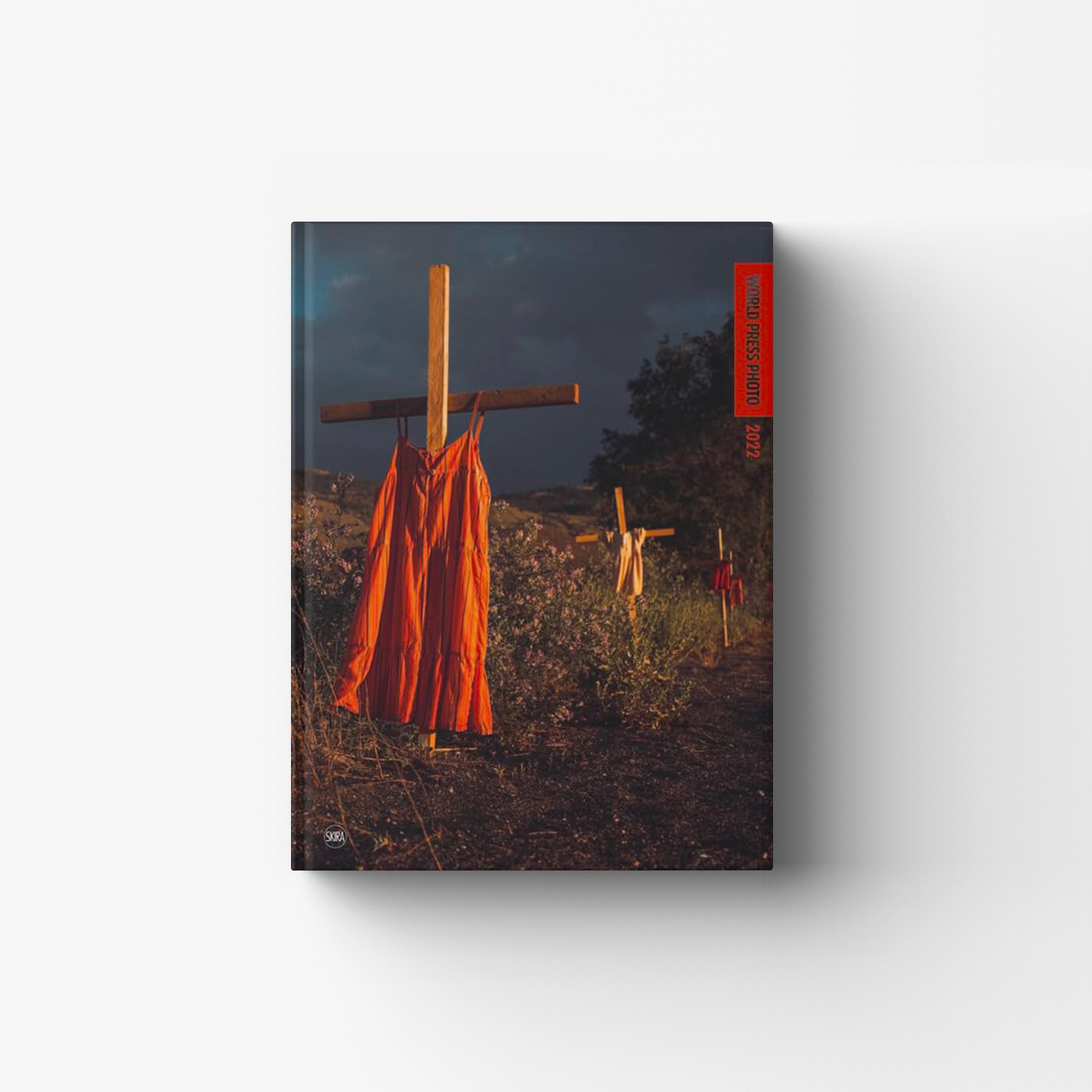 Photographic journalism book by Skira Arte with hardback cover, featuring a dark field scene and orange flags