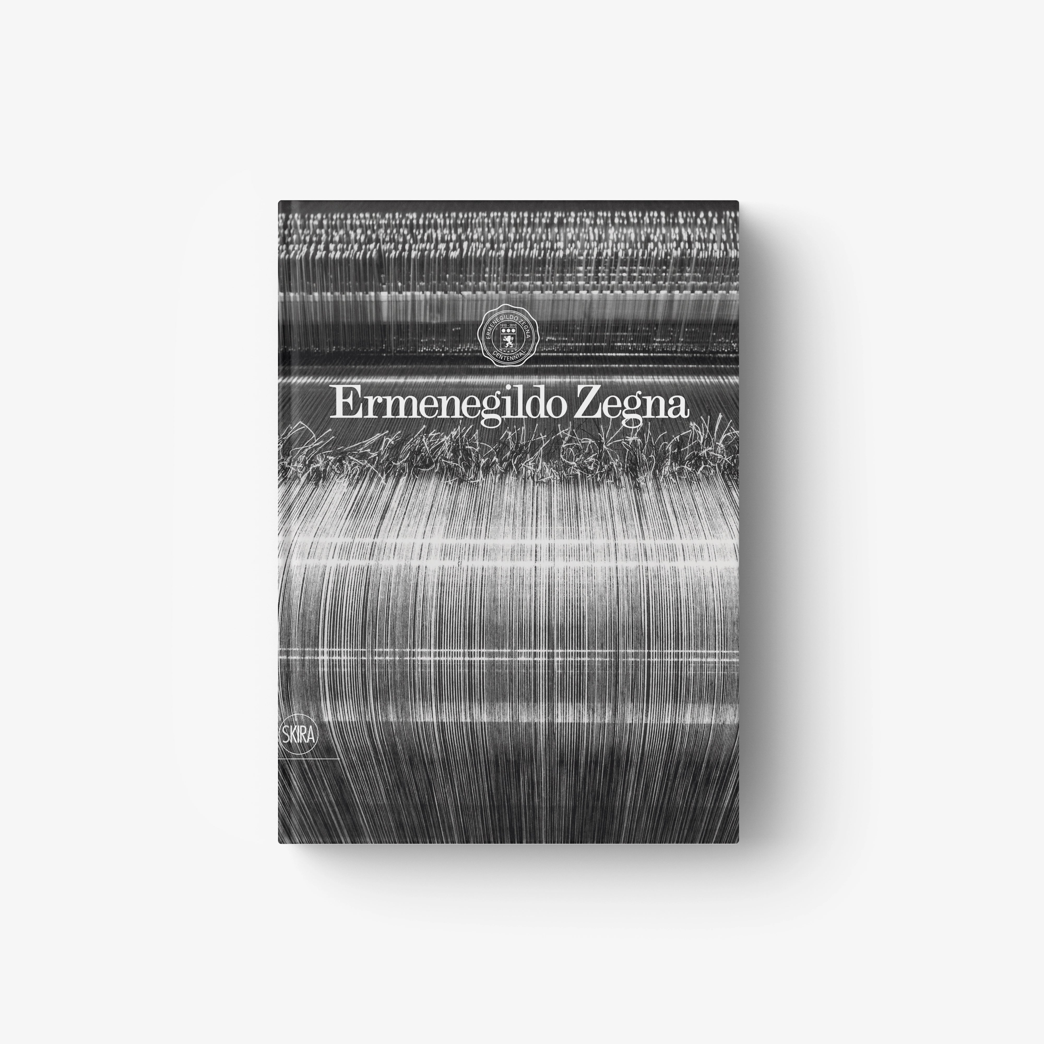 Hardcover book with Ermenegildo Zegna title on gray striped abstract cover