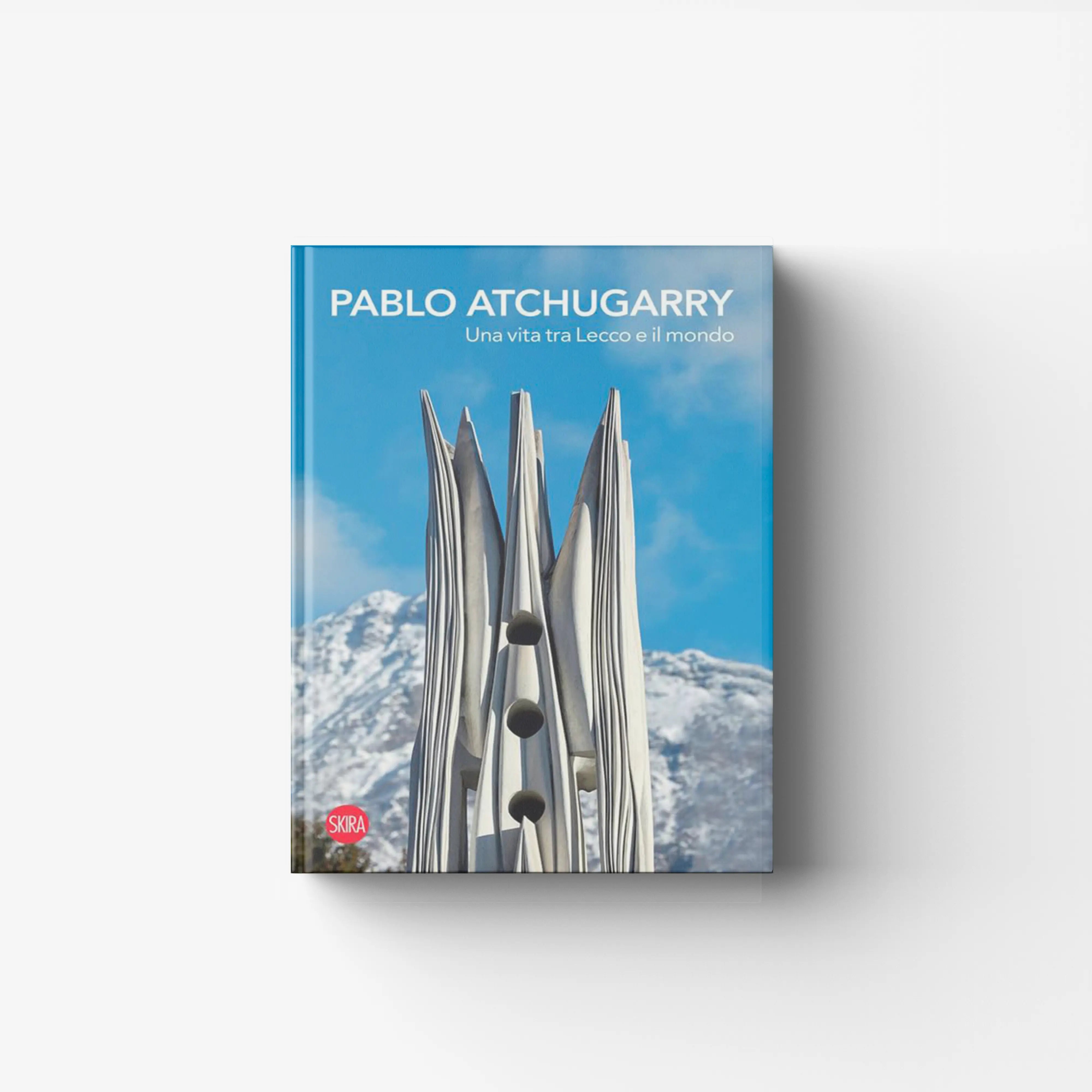 Art monograph book by Skira Arte with blue cover and silver sculptures, Pablo Atchugarry Una vita tra Lecco e il mondo